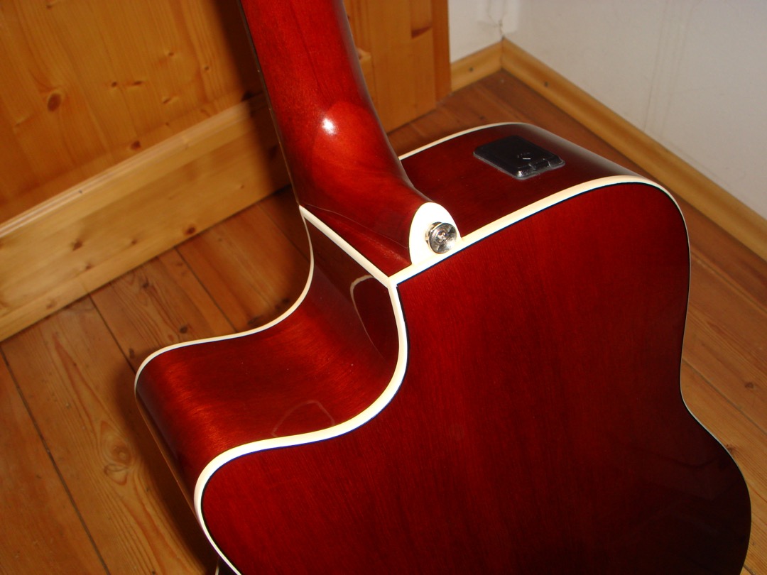 A Yamaha cutaway acoustic-electric guitar with its onboard preamp panel visible on the upper bout, the standard layout across modern acoustic-electric guitars