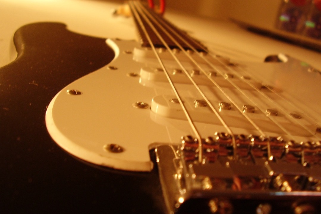 Close-up of the wound strings and pickups on an electric guitar