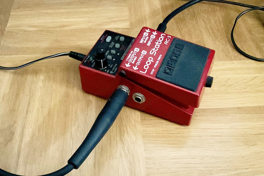 A BOSS Loop Station compact looper pedal with its instrument cable plugged in, the classic single-footswitch guitar looper format