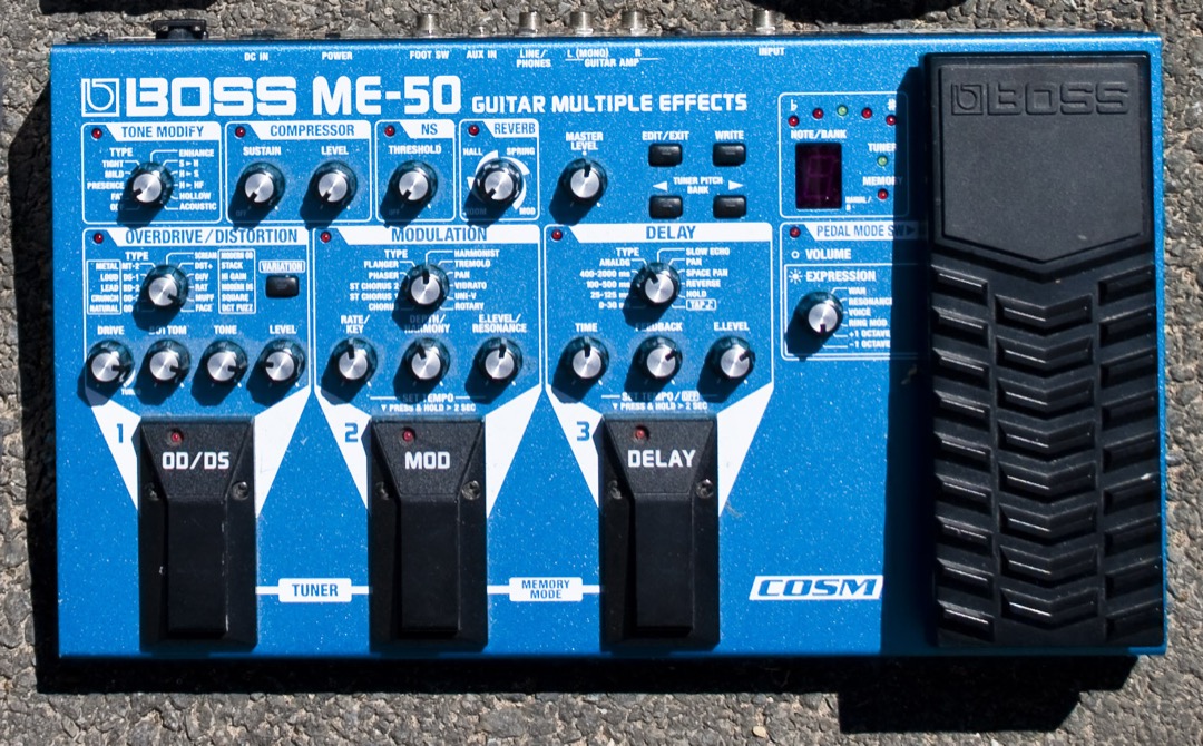A BOSS ME-series multi-effects floor processor with knob-based controls and footswitches, the classic all-in-one guitar multi-effects pedal format