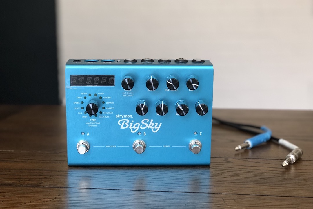 A row of guitar reverb effect pedals on a pedalboard, showing the range of sizes and brands a player chooses between