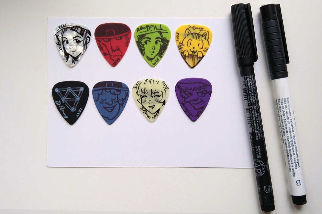 An assortment of guitar picks in different colors, shapes, and thicknesses