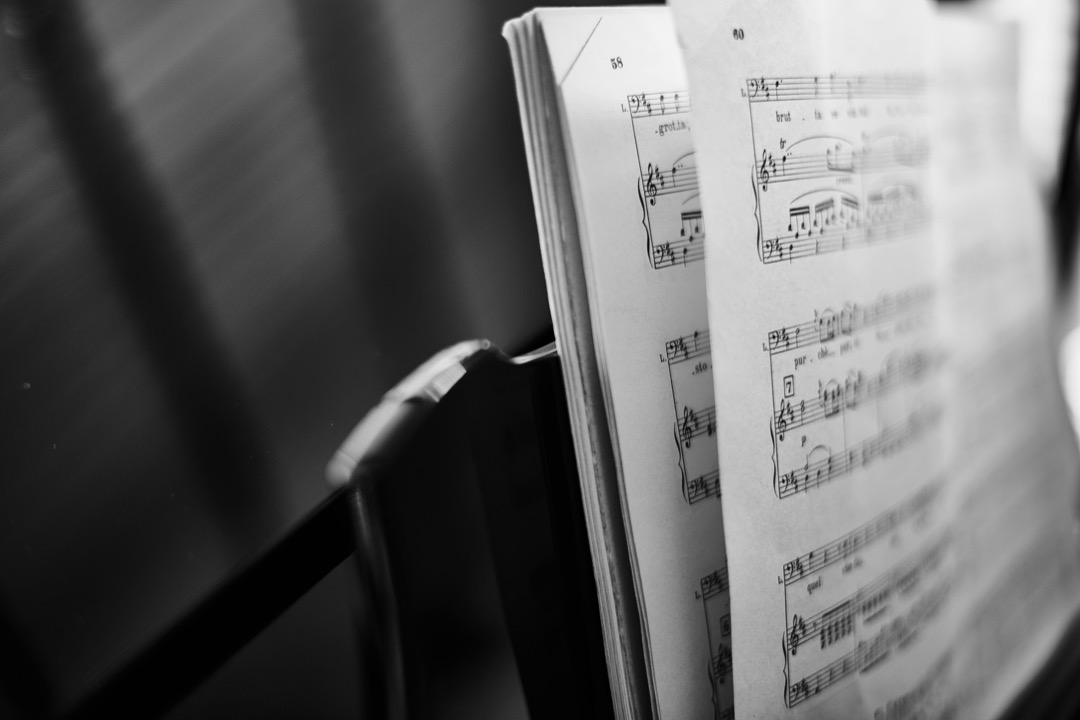 Open printed music score resting on a music stand, showing staves of standard notation