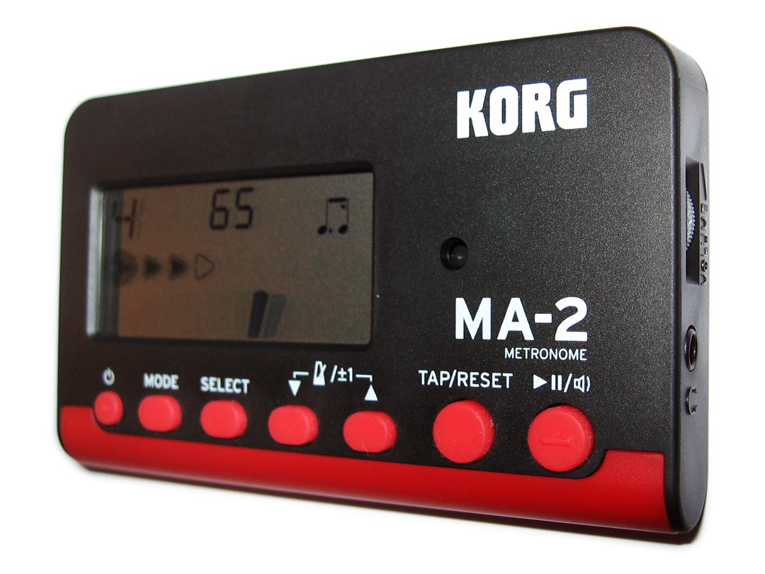 A Korg MA-2 digital metronome shown front-on and from the side on a plain background, its LCD display and tempo controls facing the camera